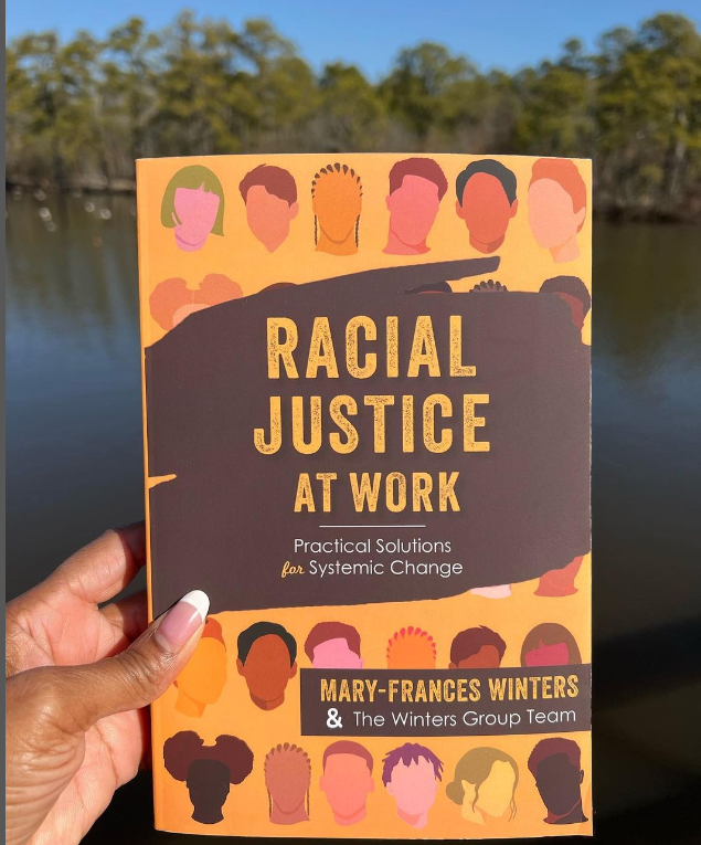 Hand holding a copy of Racial Justice at Work